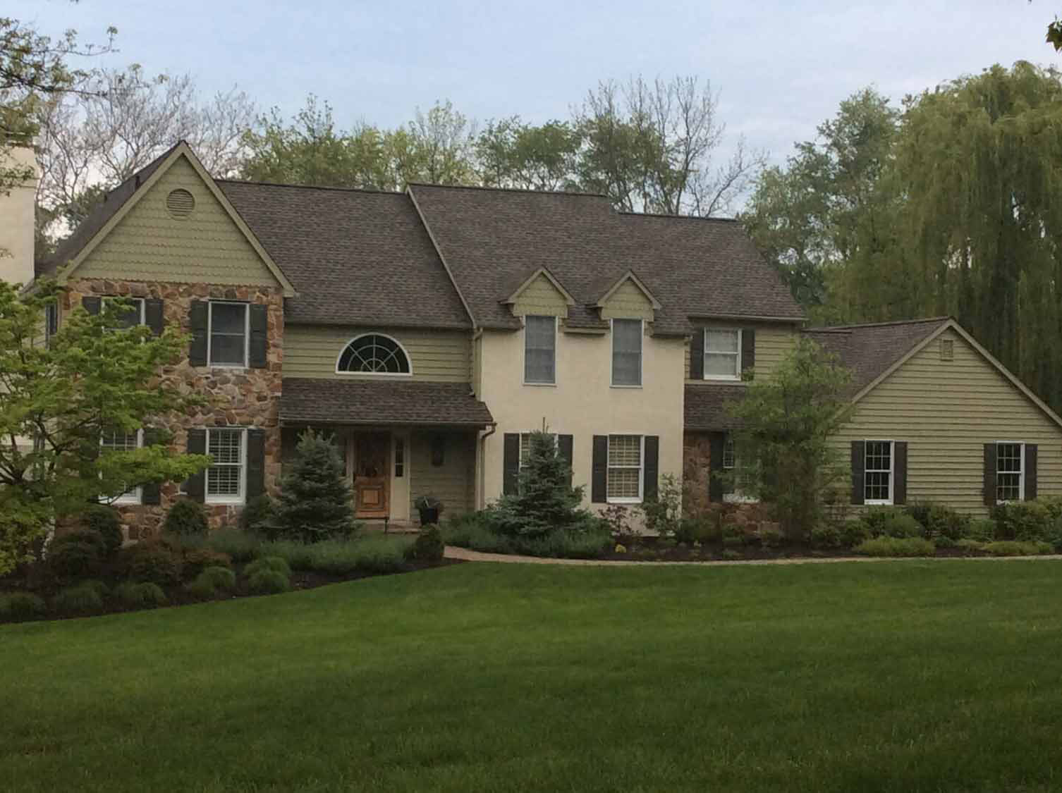 Residential roof installation on a stone and stucco home