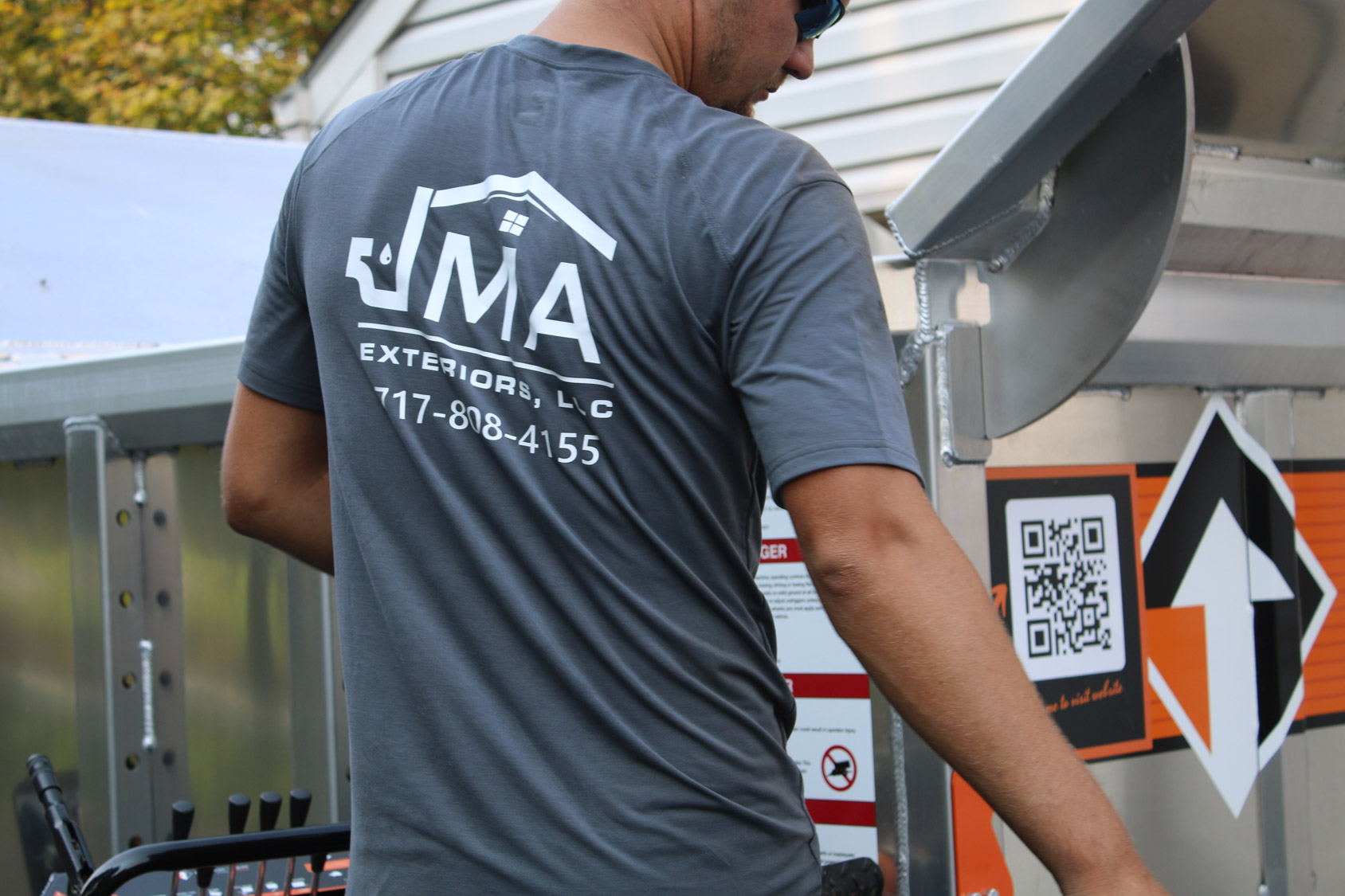 JMA Equipter roofing trailer positioned beside a home